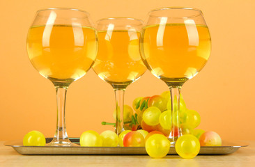White wine in glass on salver on beige background