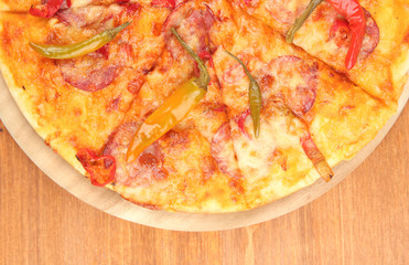 Tasty pepperoni pizza on wooden board on wooden background