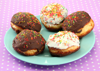 Tasty donuts on color plate on color background