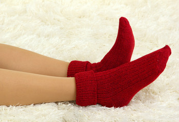 Female legs in colorful socks on  white carpet background