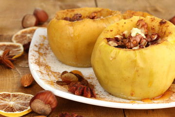 Baked apples on plate on wooden table