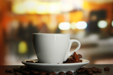 cup of coffee with beans on table in cafe