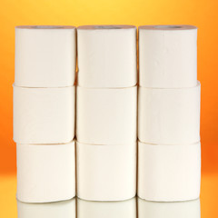 Rolls of toilet paper on orange background