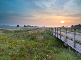 Fototapeta na wymiar Drewniany most podczas wschodu