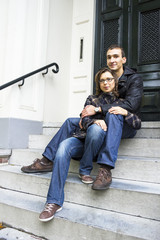 Fototapeta na wymiar Portrait of love couple sitting on traditional Dutch porch looki