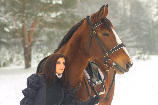 Beautiful woman and horse in winter