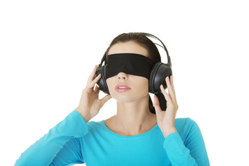 Blindfold attractive woman with headphones