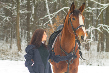 Obraz premium Beautiful woman and horse in winter