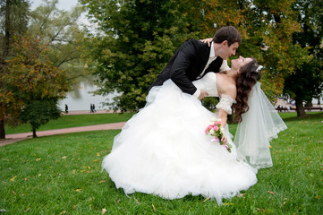Newly married couple dancing in field