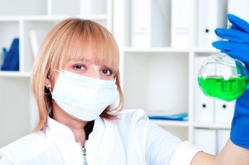 Woman chemist with the flask in a laboratory