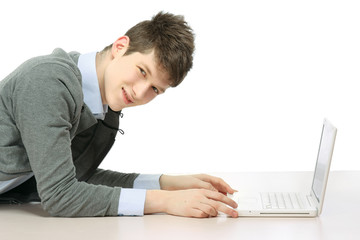 A college guy with a laptop lying on the floor, side-view