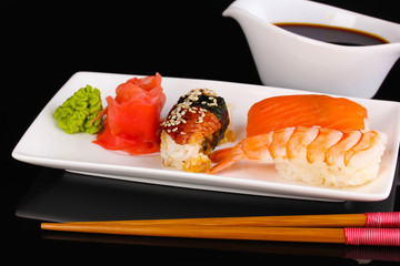 delicious sushi served on plate isolated on black