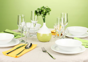 Table setting in green and yellow tones on color  background