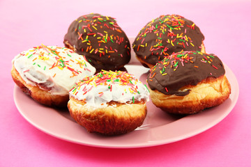 Tasty donuts on color plate on color background
