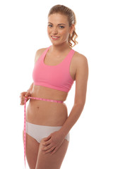 Fit young woman measuring her waist