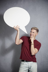 Joyous man holding empty speech balloon.