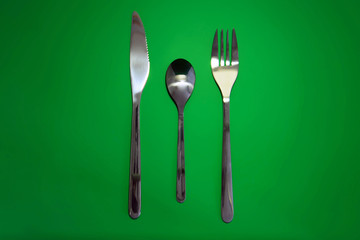 Table serving-dishware on green backdrop.