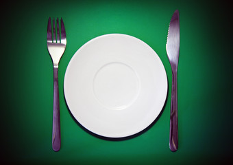 Table serving-dishware on green backdrop.