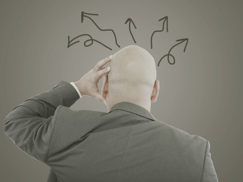 Worried businessman with arrows in different directions