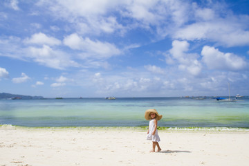 Fototapeta na wymiar Dziewczynka dziecka w kapelusz latem na tropikalnej tle morza