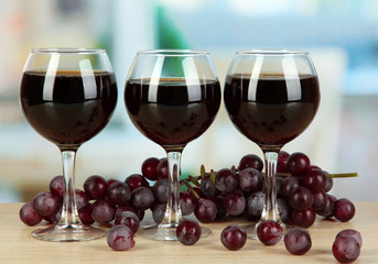 Red wine in glass on room background
