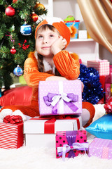 Dreaming little girl in suit of squirrels surrounded by gifts