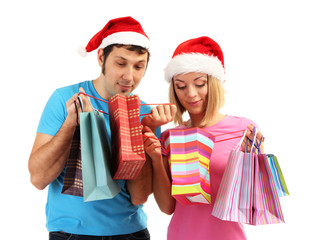Young couple in Santa hats shopping and holding many shopping