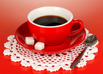 A red cup of strong coffee on red background