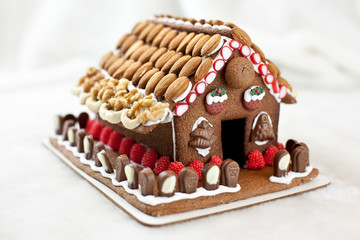 Świąteczny domek z piernika z bakaliami bogato zdobiony
