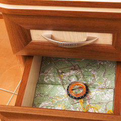 Fototapeta na wymiar mapa i kompas w otwartej szufladzie biurka