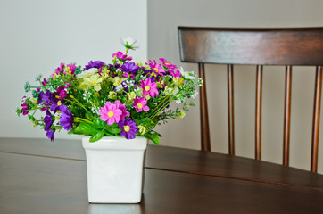 Fototapeta na wymiar Decoration artificial flower on wooden table