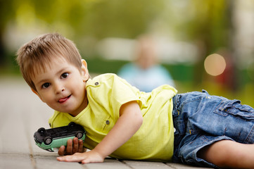 little boy plays with toy car