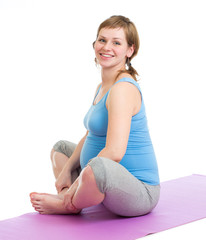 Pregnant woman doing gymnastic exercises isolated  on white