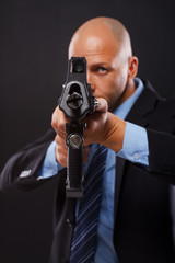 Serious man in a suit holding a rifle