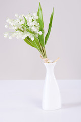 Lily-of-the-valley in a vase isolated on light background