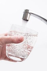 Wasserglas wird am Wasserhahn gefüllt
