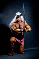 Muscular man with a sword and long white hair.