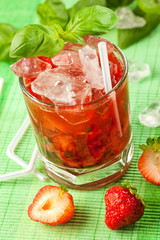 Red drink on a green background and ice