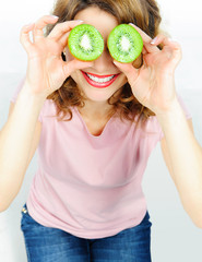 Funny woman holding kiwis fruit for her eyes. Isolated on white