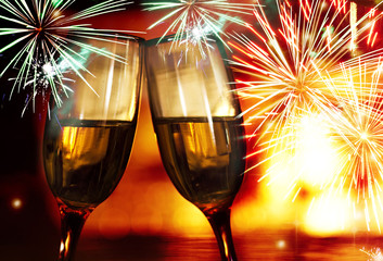 champagne glasses against  fireworks