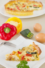 Slice of vegetarian quiche on plate.