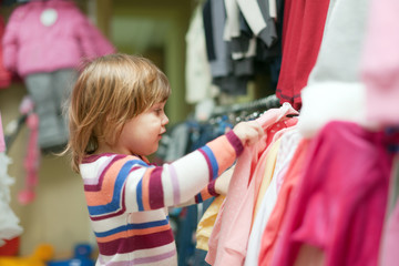  baby girl  chooses clothes at shop