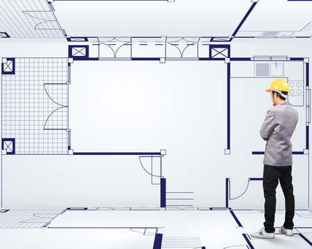 Engineering person standing near a House blueprints