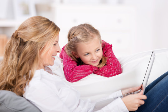 mutter und tochter schauen auf den laptop