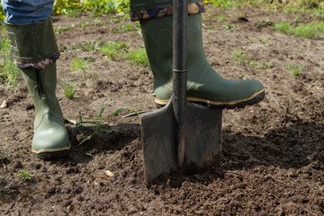 digging in green boots, close-up
