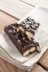 Delicious chocolate bar with almonds on canvas