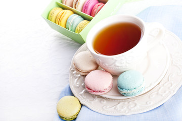 Cup of tea with colorful french macarons