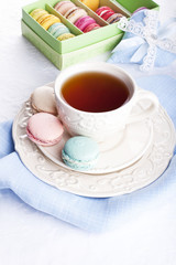 Cup of tea with colorful french macarons