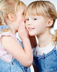 Little girls sharing a secret