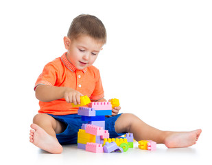 cheerful child boy playing with construction set over white back